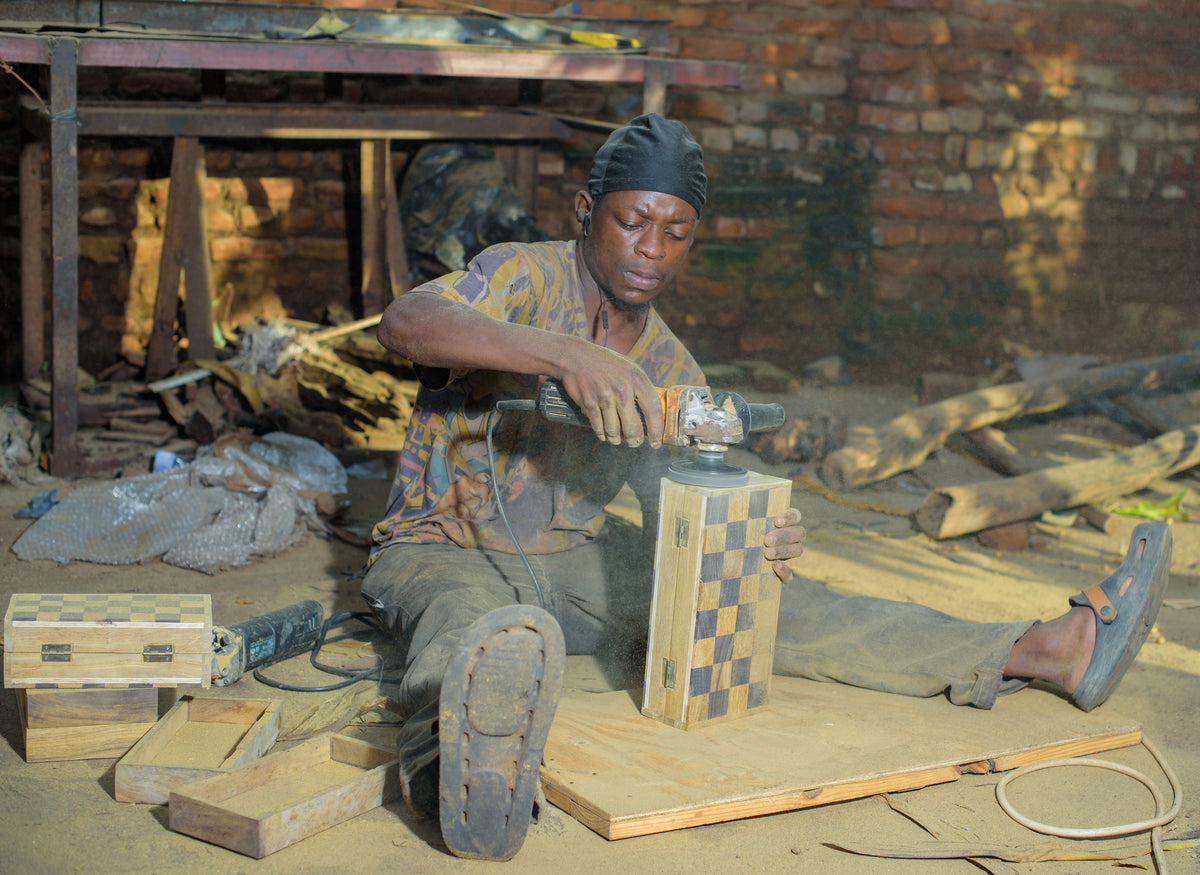Things from Africa artisan handcrafting a wooden chess piece