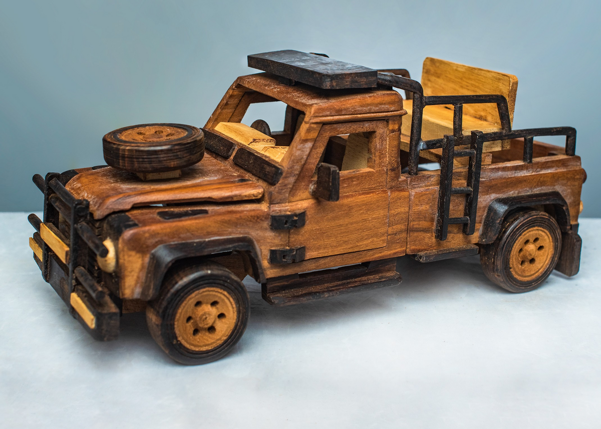 Handcrafted wooden safari game viewer shown from the front and side, with open rear seating, black safety rails and a spare wheel on the bonnet.